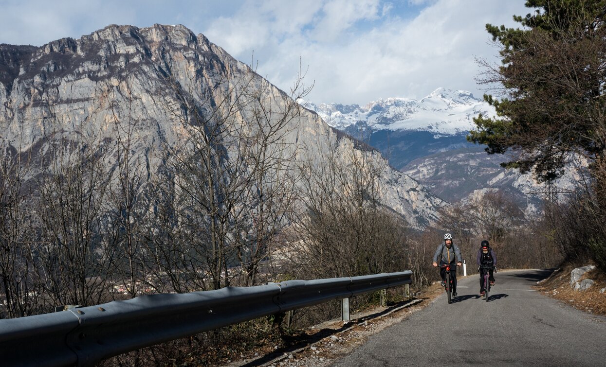 Der Aufstieg mit den schneebedeckten Gipfeln der Brenta im Hintergrund | © Archivio Garda Trentino (ph. Marco Giacomello), Garda Trentino Der Aufstieg mit den schneebedeckten Gipfeln der Brenta im Hintergrund | © Archivio Garda Trentino (ph. Marco Giacomello), Garda Trentino