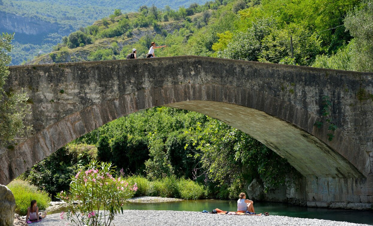 Die Römische Brücke in Ceniga mit dem kleinen Strand am Fluss | © Archivio APT Garda Trentino (ph. Promovideo), Garda Trentino 