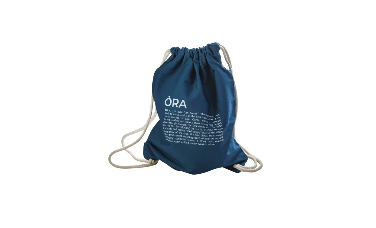 Uno zaino blu con cordini bianchi. Ha un testo bianco stampato su un lato.