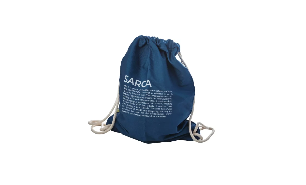 Ein Rucksack aus blauem Stoff mit weißen Schnürsenkeln. Das Design zeigt einen Schriftzug auf der Vorderseite.