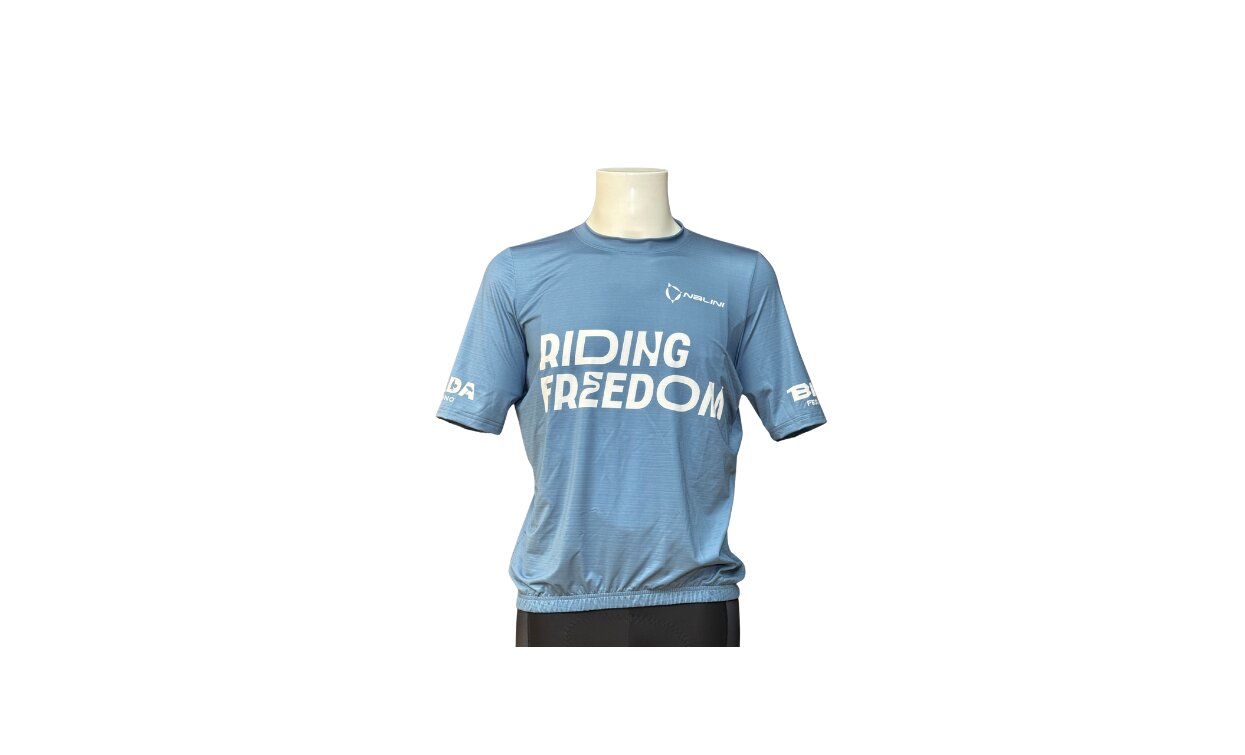 Ein hellblaues T-Shirt mit der Aufschrift "RIDING FREEDOM" auf der Vorderseite. Das Design ist einfach und geeignet für Aktivitäten im Freien.