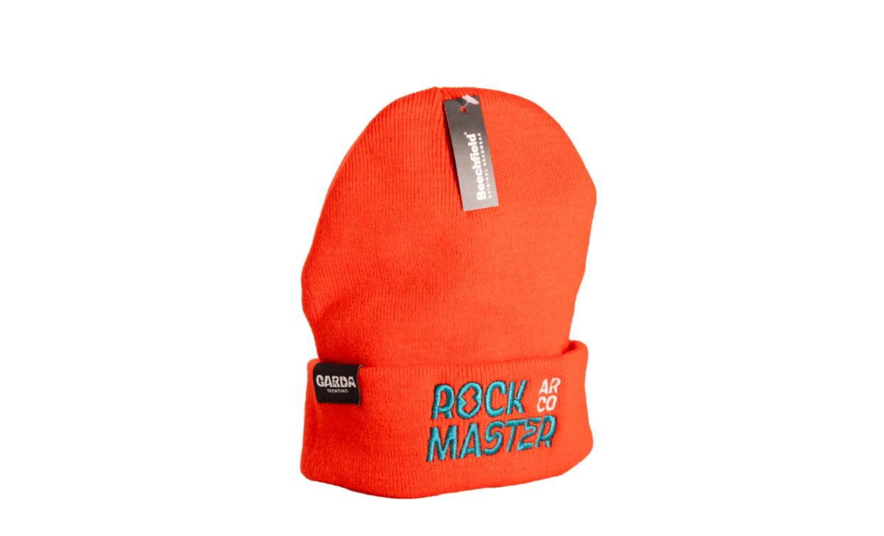 Eine orangefarbene Mütze mit der aufgestickten Schrift "ROCK MASTER". Sie ist ein modisches Accessoire, das perfekt für den Winter ist.